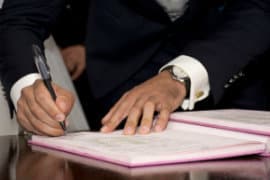 man-signing-papers